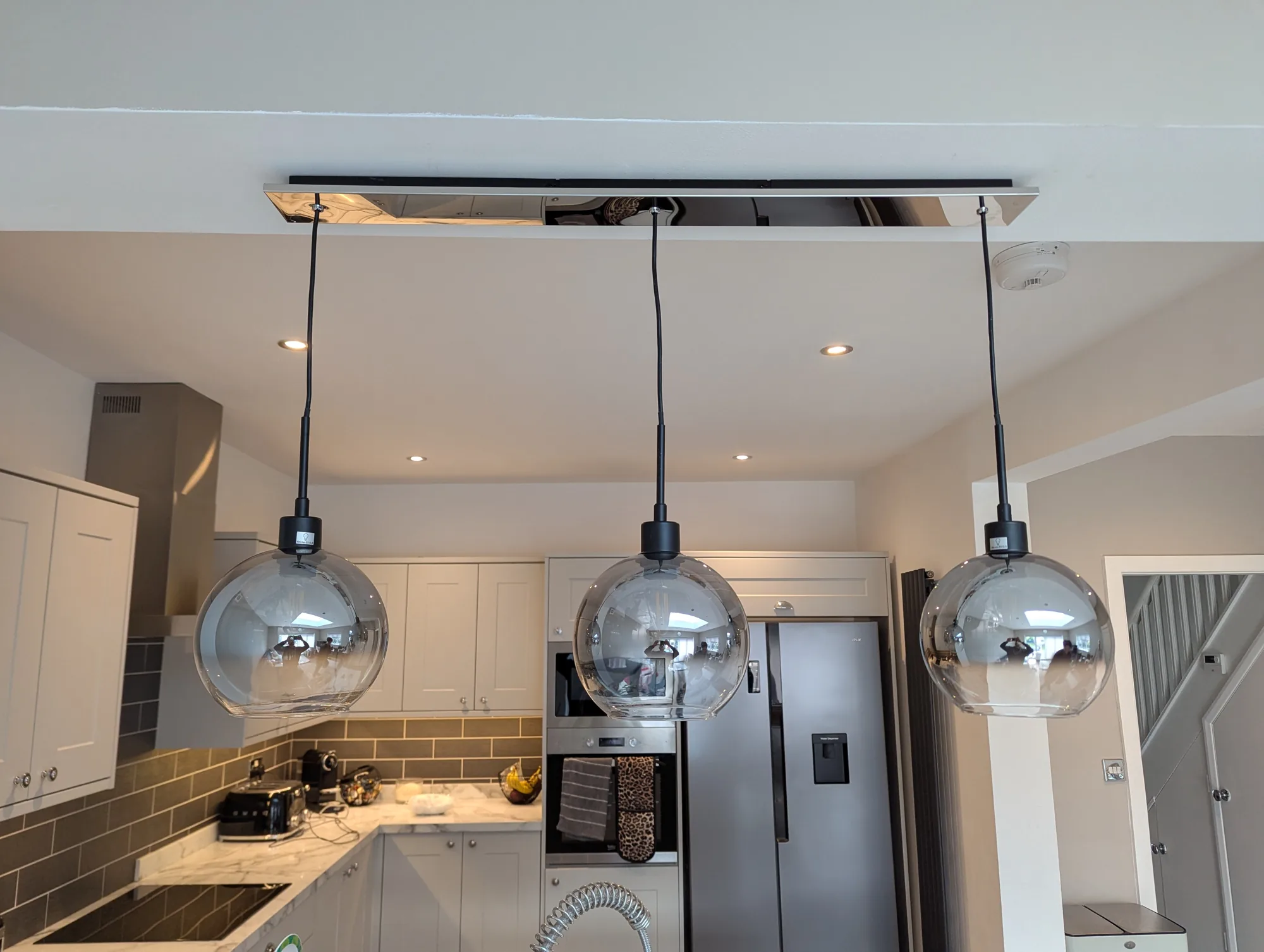 Chrome globe pendant lights over a modern kitchen